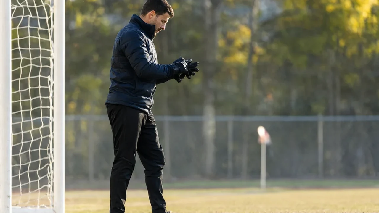 Pair of vivid goalkeeper gloves palms-up on bright grass